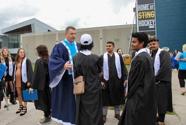 Rob Kardas chatting with a group of international students after convocation.