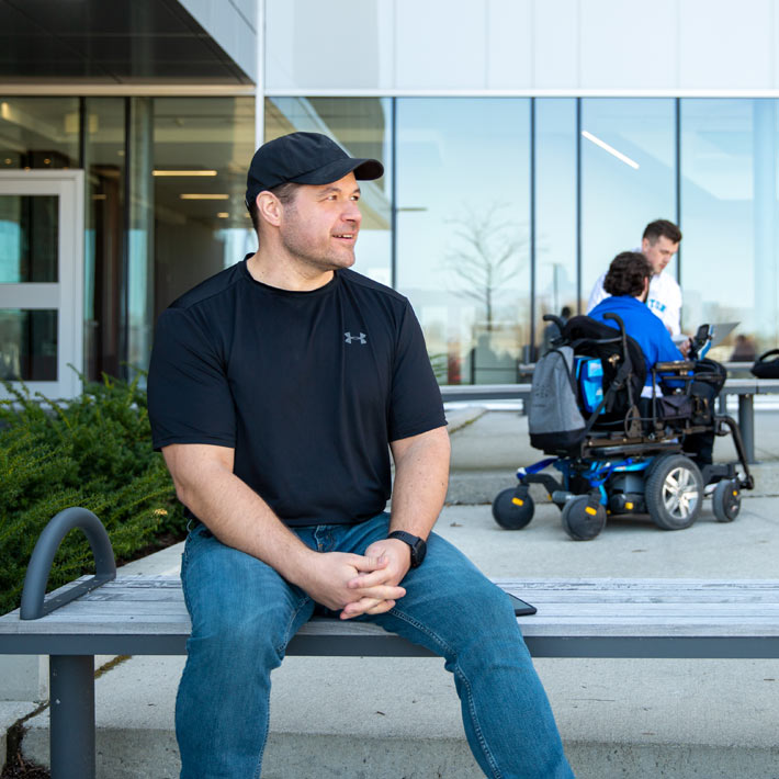 Student sitting in front of Lambton College