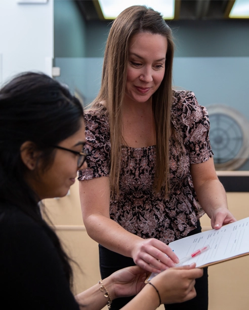 Receptionist hands student paperwork