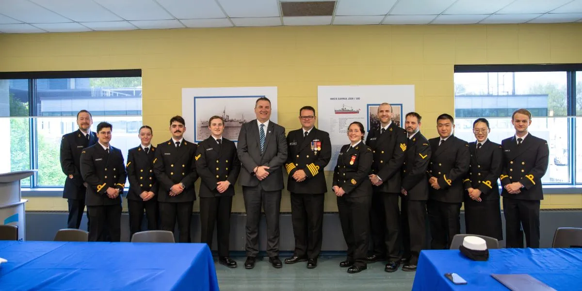 Military academy students standing with Rob Kardas