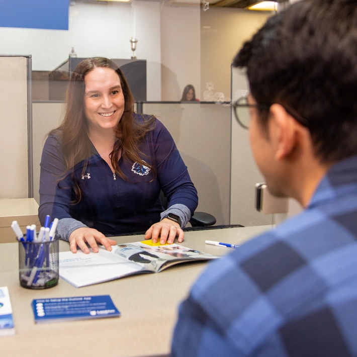 Office of the registrar staff member helping student.