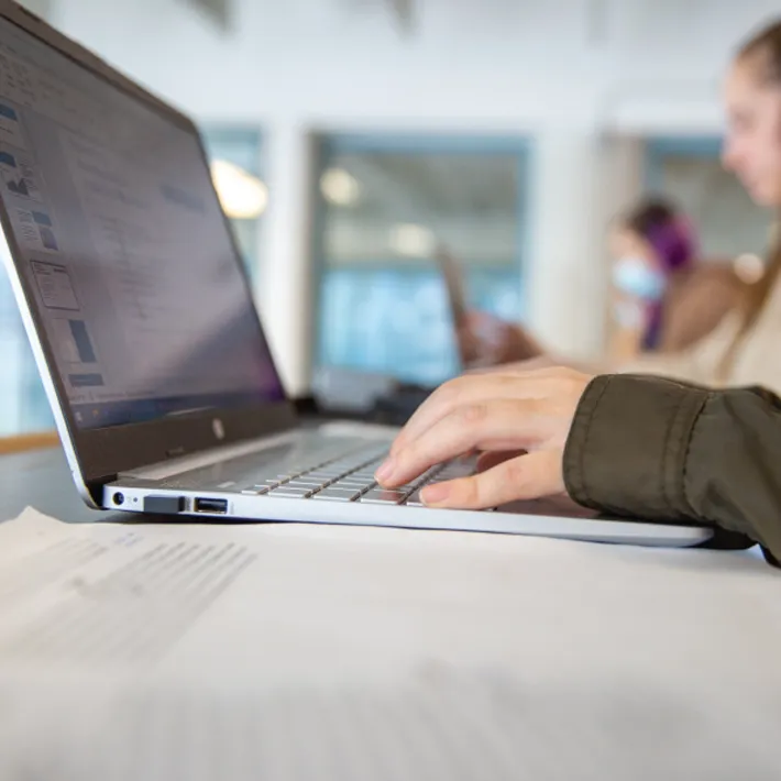 A close-up photo of a a student using a laptop.