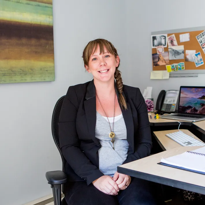 Graduat student sitting at desk posing for photo.