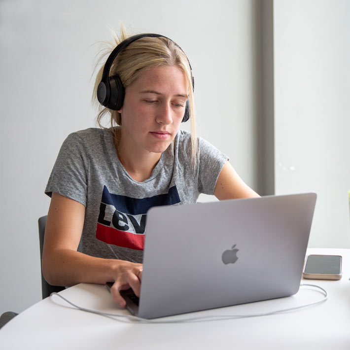 Student wearing headphones and using laptop