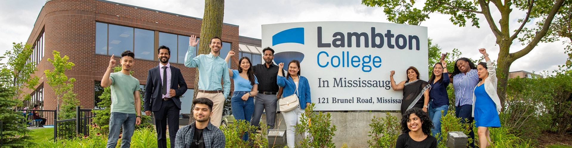 A group of students posing for a photo outside the Queens campus.