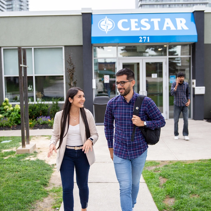 Two students walking out of the Cestar campus building.
