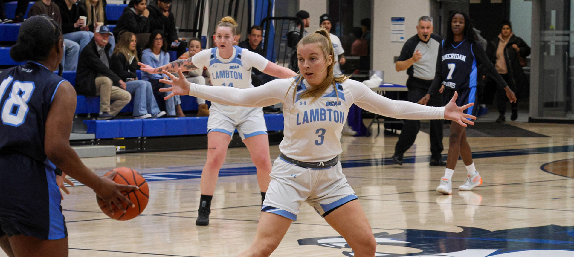 A photo of Lambton's women basketball team on the court playing against Sheridan