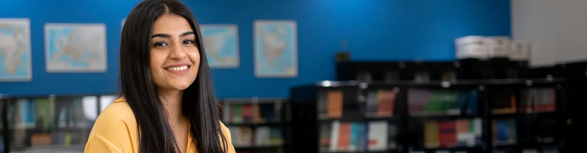 An international student posing for photo in library.