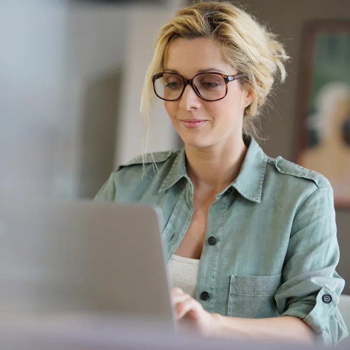 Woman working on curriculum on laptop.