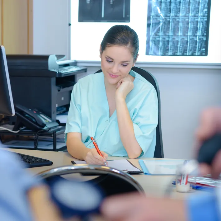 Medical Transcriptionist sitting at desk transcribing.