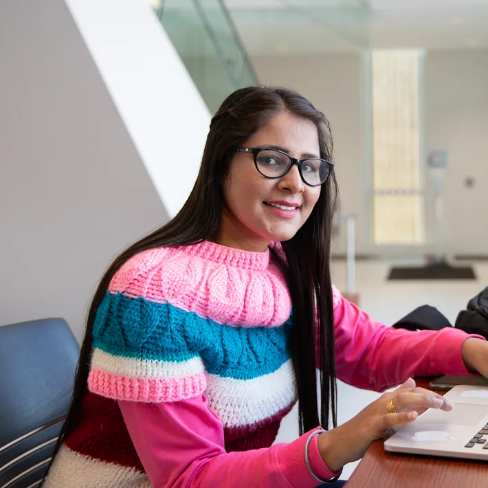 Student on lambton college campus studying in hallway.