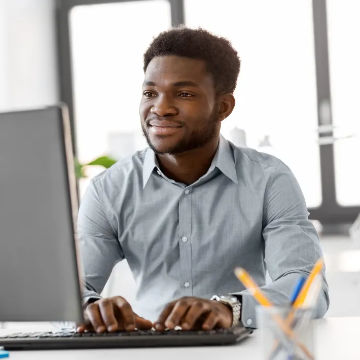 Data analyst sitting at computer typing on keyboard.