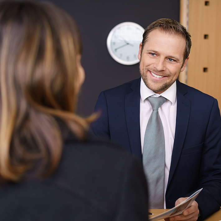 Man smiling behind desk