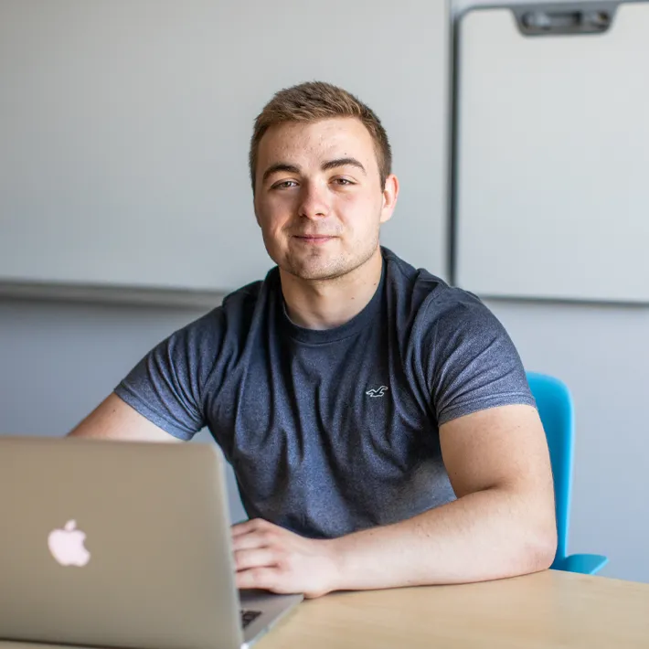 Student sitting at desk with computer.