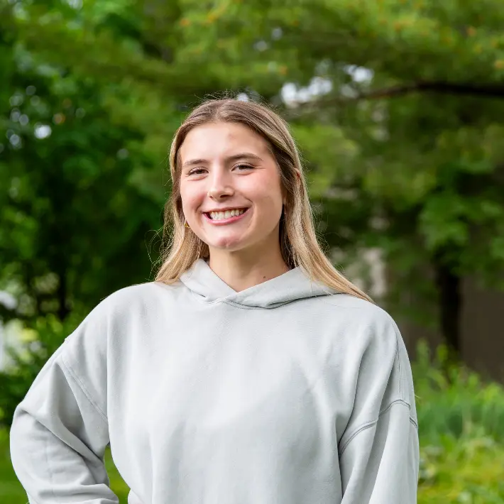 A student standing in one of Lambton College's green spaces