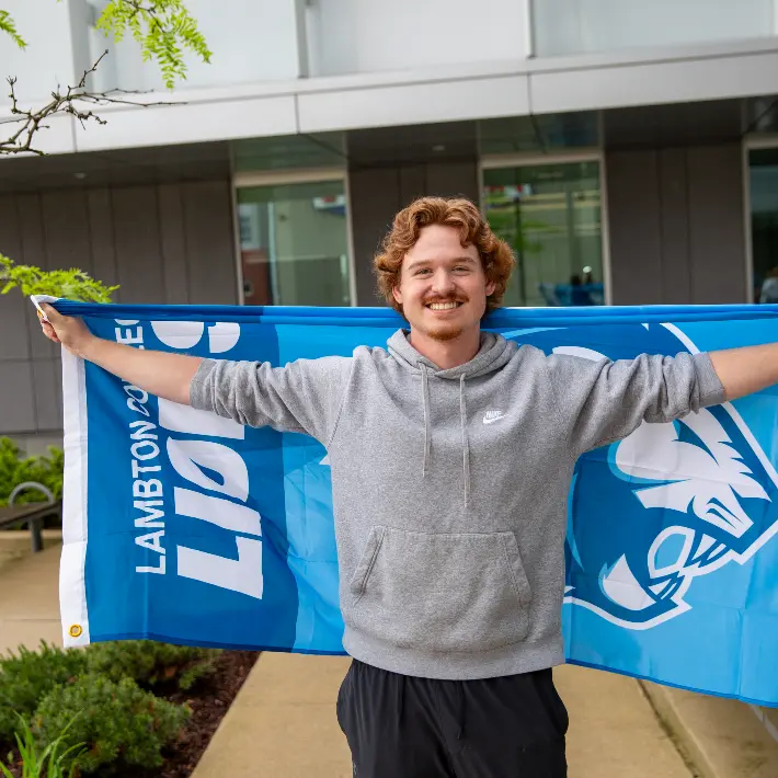 Student holding lambton lions flag