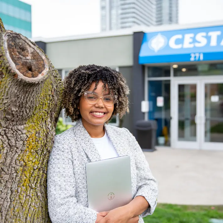 A student leaning against a tree