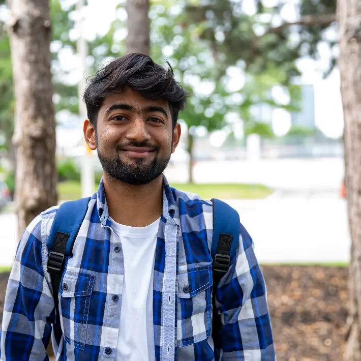 A student standing in a green space