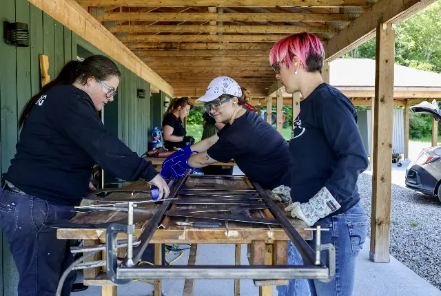 Women in technology and trades making a metal sign at Camp Ak O Mak