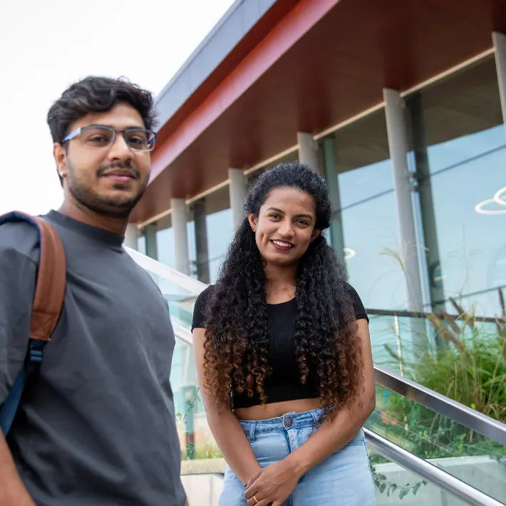 two-students-standing-outside Two students outside of the building