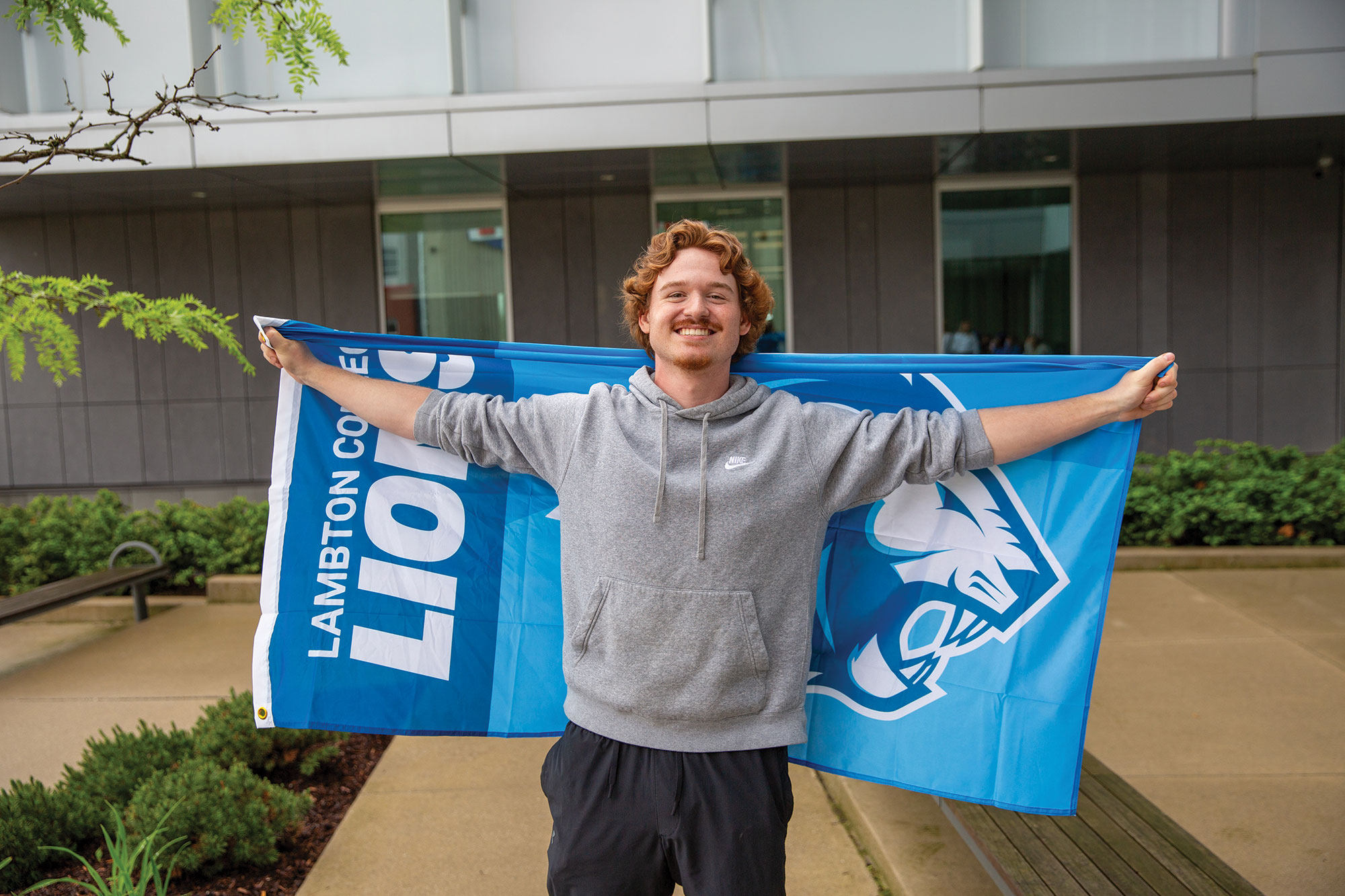 A student holding a Lambton Lions flag