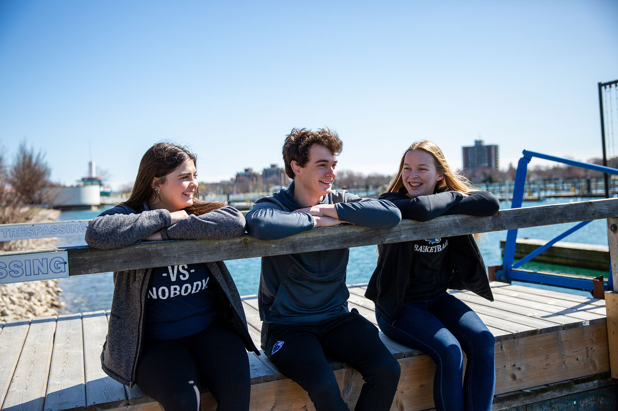 Students sitting on a dock at the beach